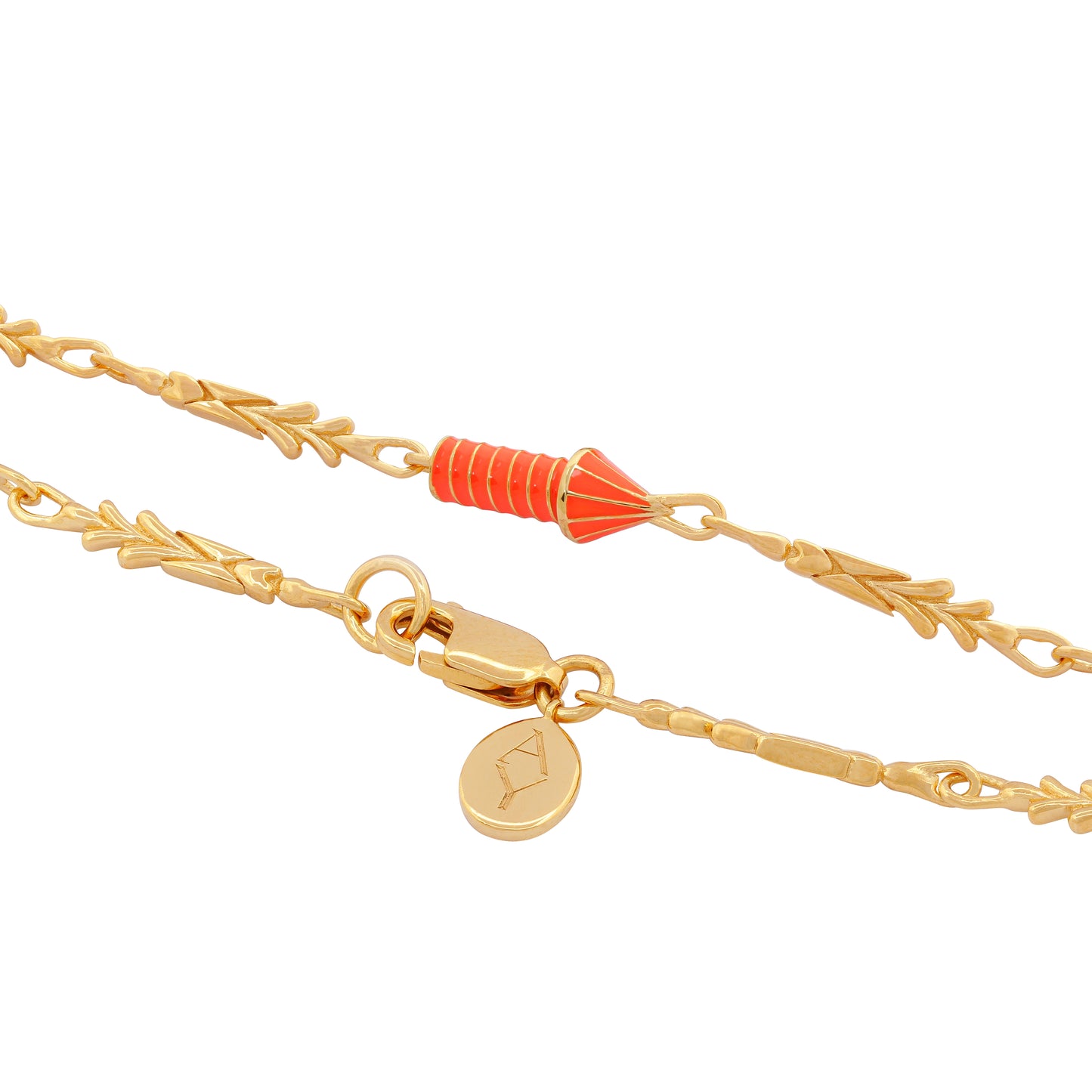 image of gold charm bracelet with orange enamel rocket, close up view of rocket and lock with logo tag