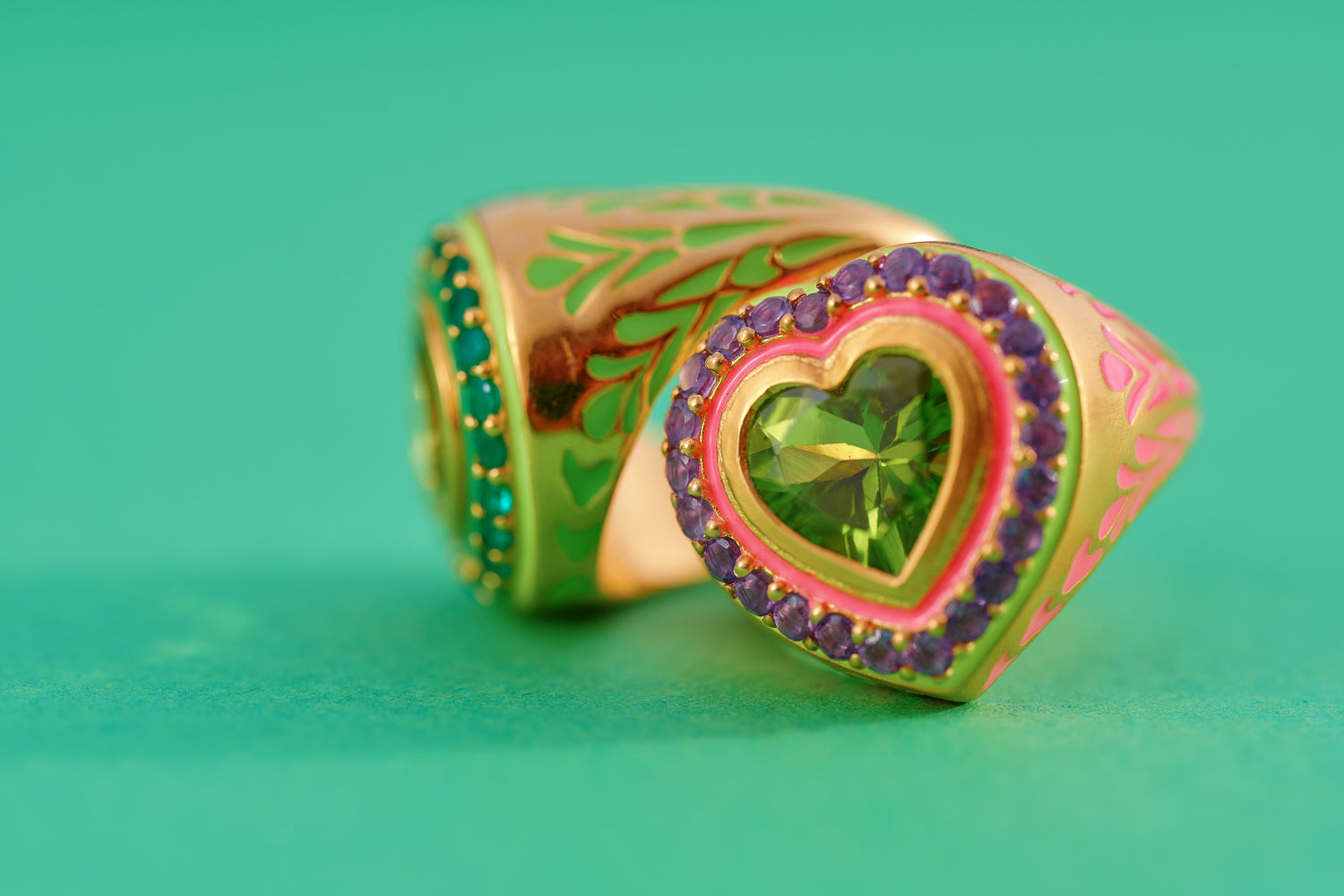 image of firework heart ring and statement ring in green and gold on bright green background