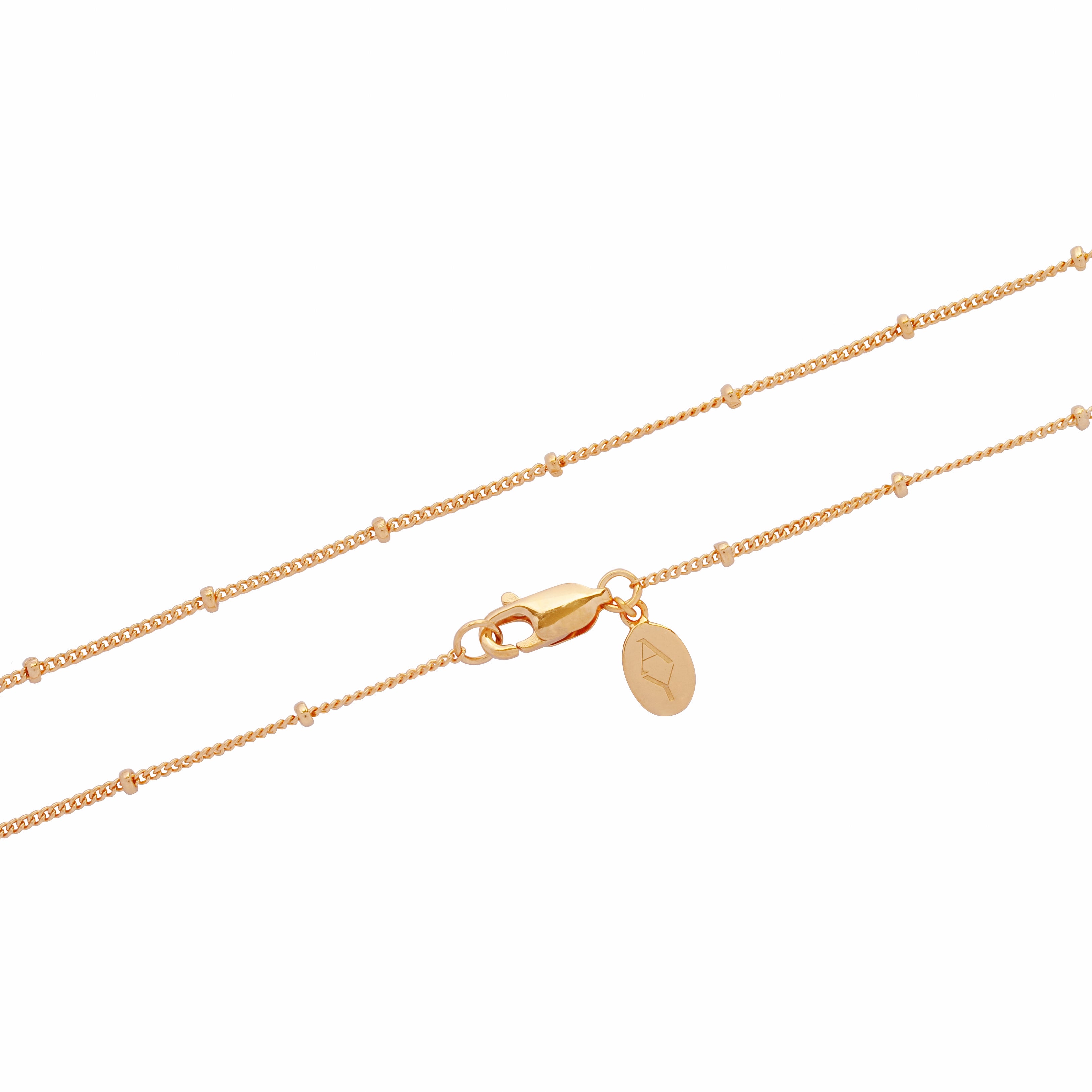 image of close-up of ball chain in gold showing lock and logo tag