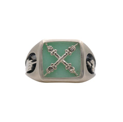 A signet ring with a square chrysoprase stone and an emblem depicting two hands on columns, with one hand's fingers crossed and the other bearing their middle finger.