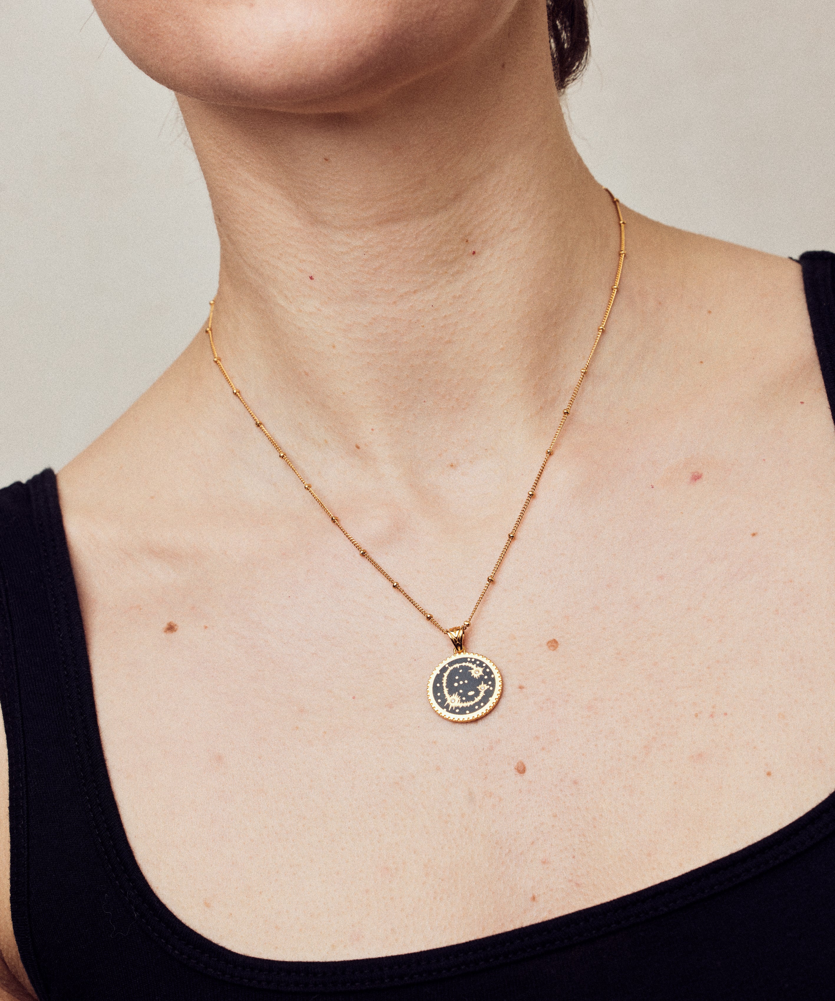 image of sparkler diamond initial necklace, letter C on short chain, on model in black tank top