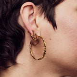 image of firework hoop earring stack on ear of model with short brown hair