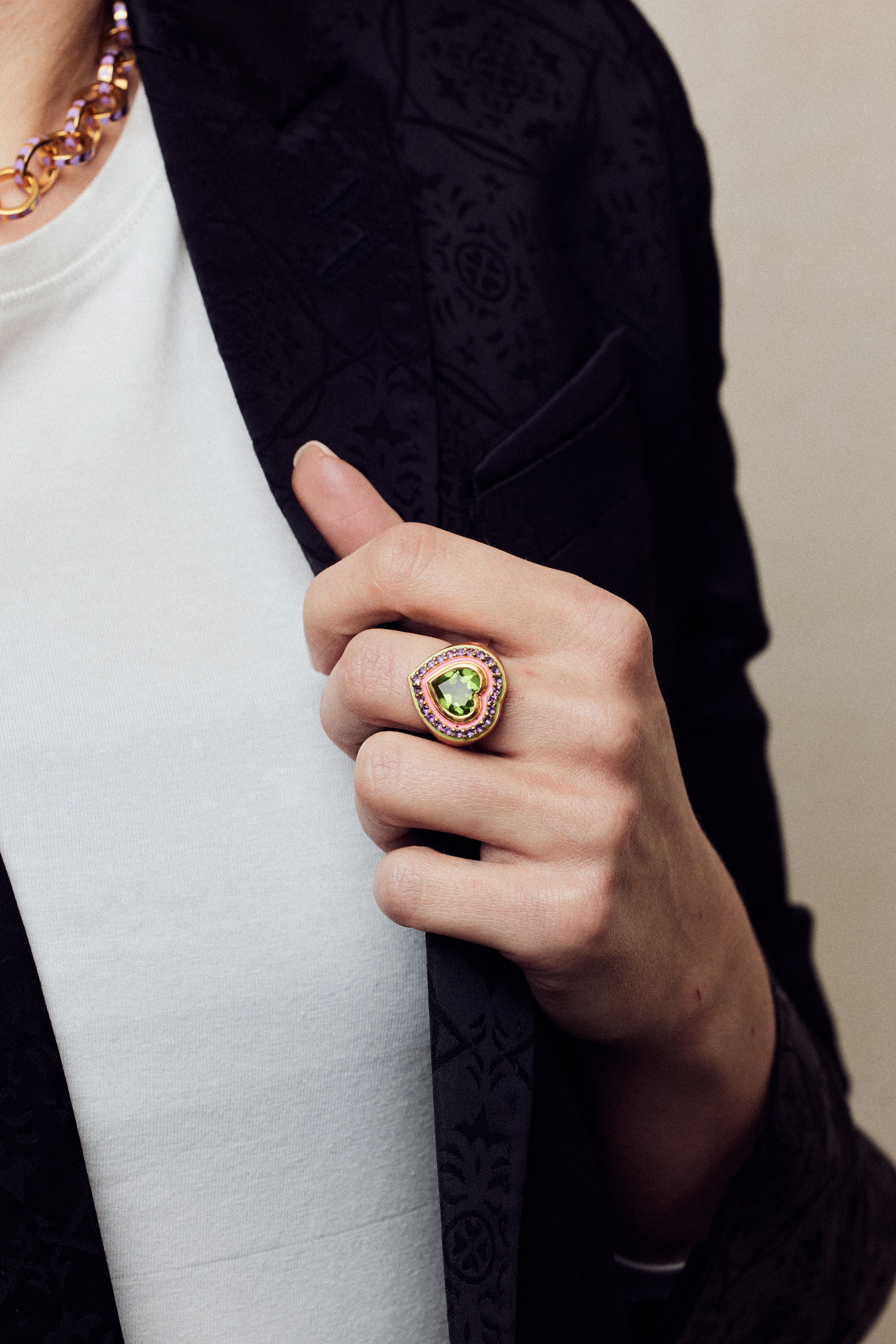 Image of firework heart ring on hand holding lapel of black jacket