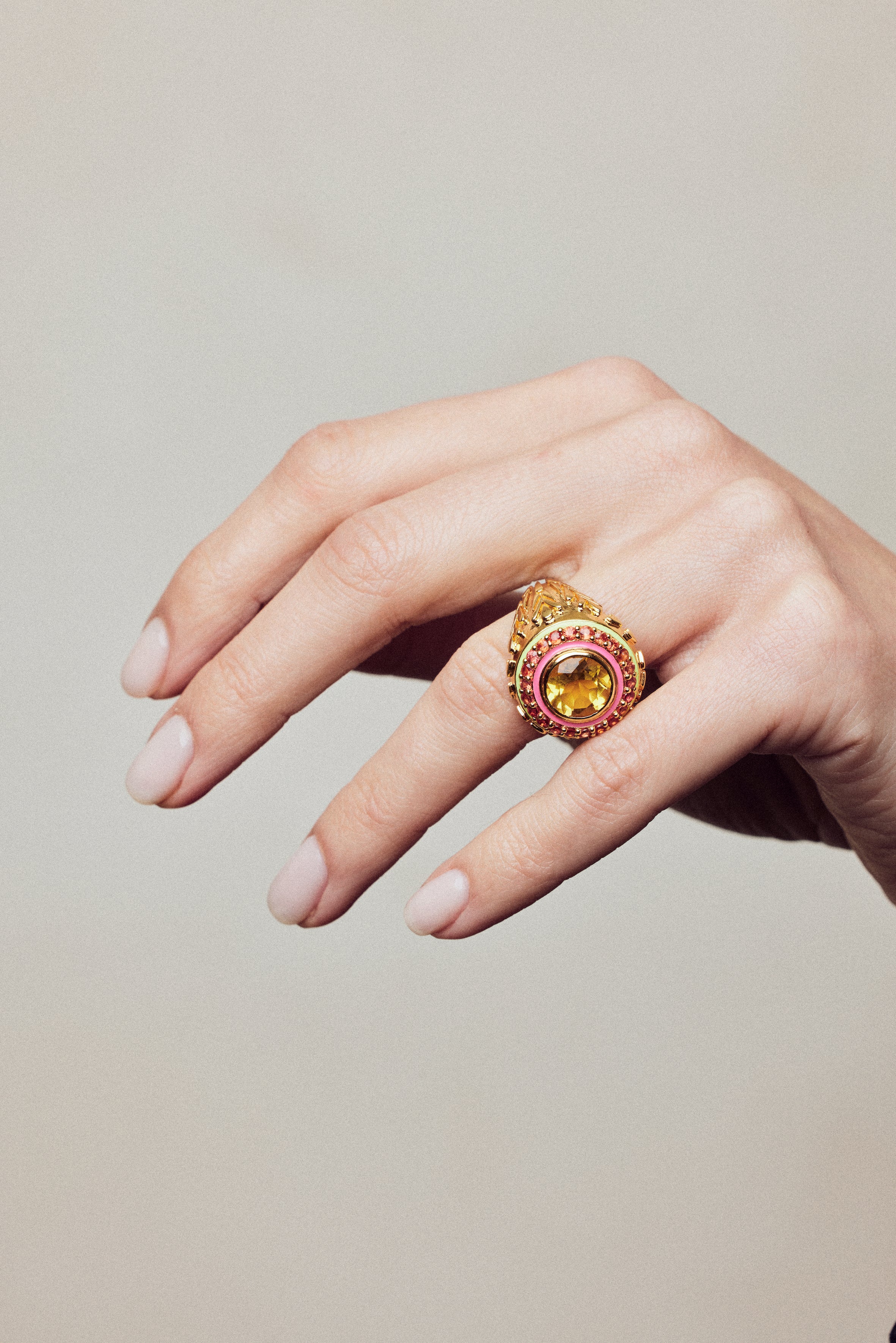 image of firework statment ring in orange and gold on hand with curled fingers