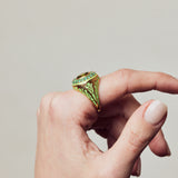 image of firework statement ring in green and gold on hand with curved fingers