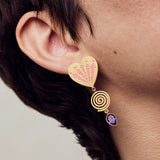 image of firework heart earrings in pink, purple and gold close up on model ear lobe