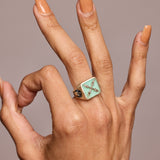 A signet ring with semi-precious stone chrysoprase worn on a hand giving the A okay sign