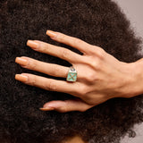 A signet ring with semi-precious stone chrysoprase showing introvert motif on a hand with it resting against their hair
