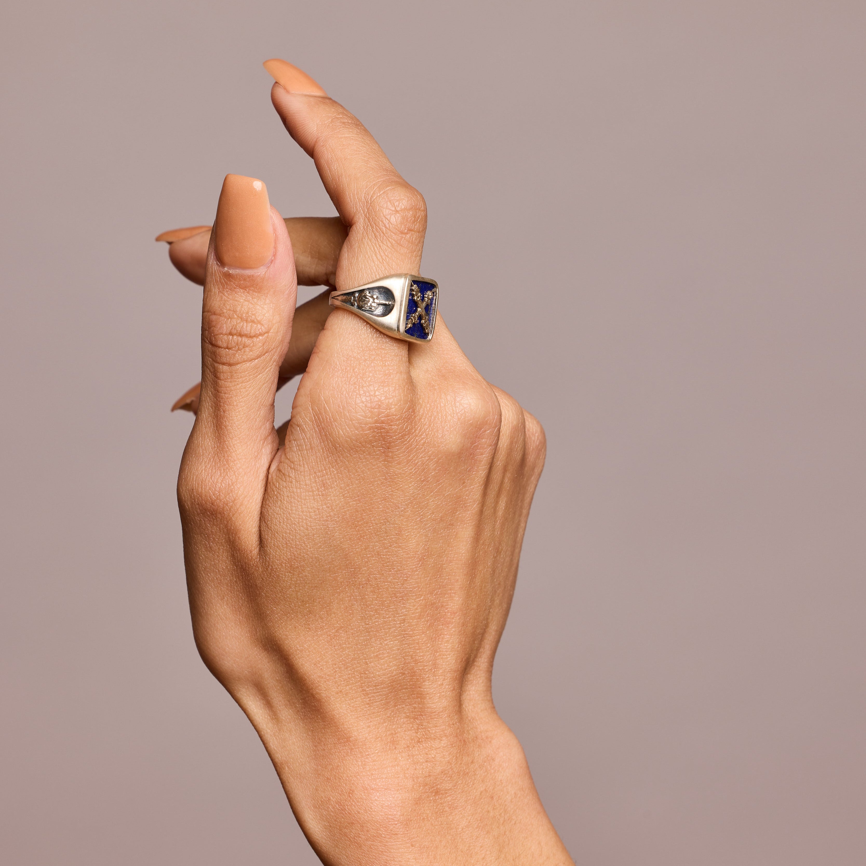 Lapis Introvert stone signet ring on hand on grey background
