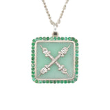A square-shaped necklace pendant with a crest motif design, featuring chrysoprase and natural emeralds, set in recycled sterling silver, displayed on a chain.