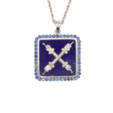 A necklace with a square pendant featuring a silver emblem on a lapis lazuli background, surrounded by blue sapphires, and a chain attached to the top.