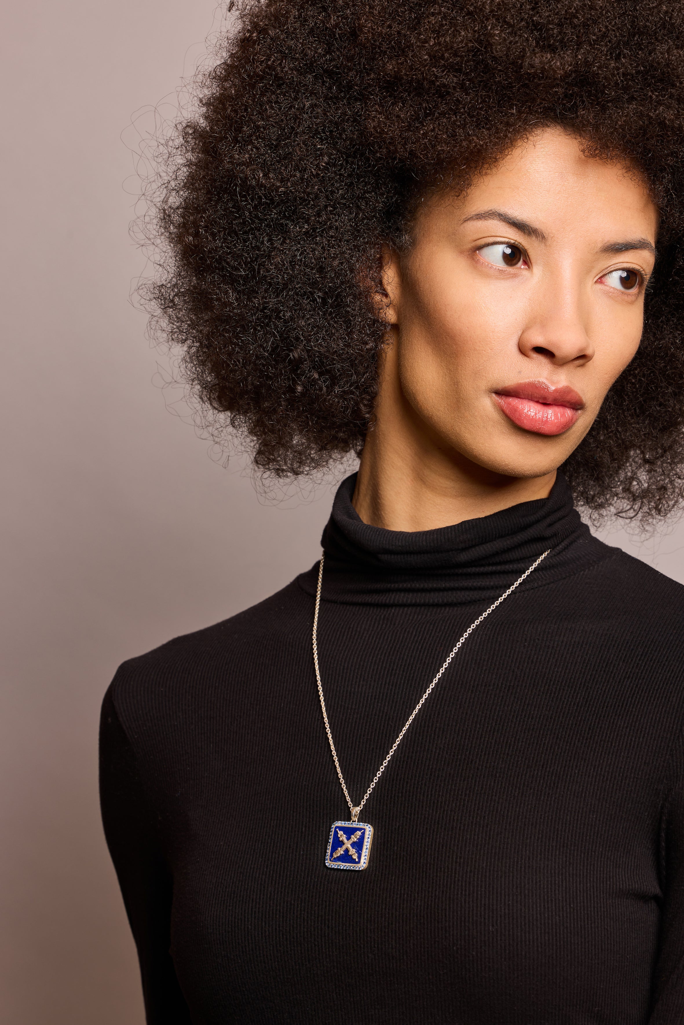 Introvert crest necklace in sapphire and lapis on long silver chain on model in black top
