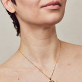 image of sparkler diamond initial necklace in black and gold shown on model with short brown hair