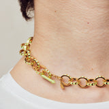 image of spark gold chain necklace in neon yellow and gold shown close up on neck of model with white skin and short brown hair