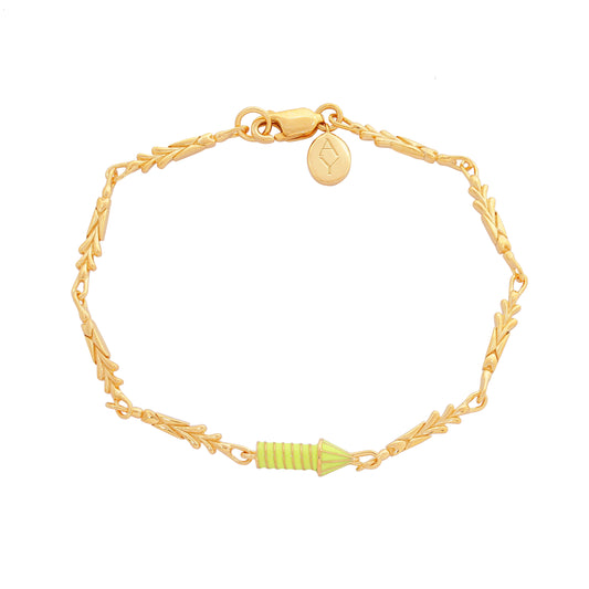 image of gold charm bracelet with yellow enamel rocket top down view flat on white background